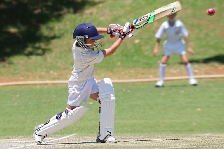 a small boy playing cricket in the playground