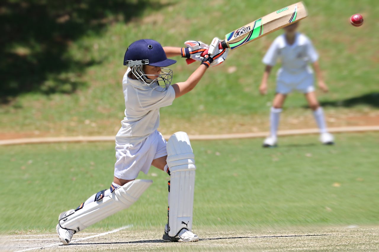 a small boy playing cricket in the playground